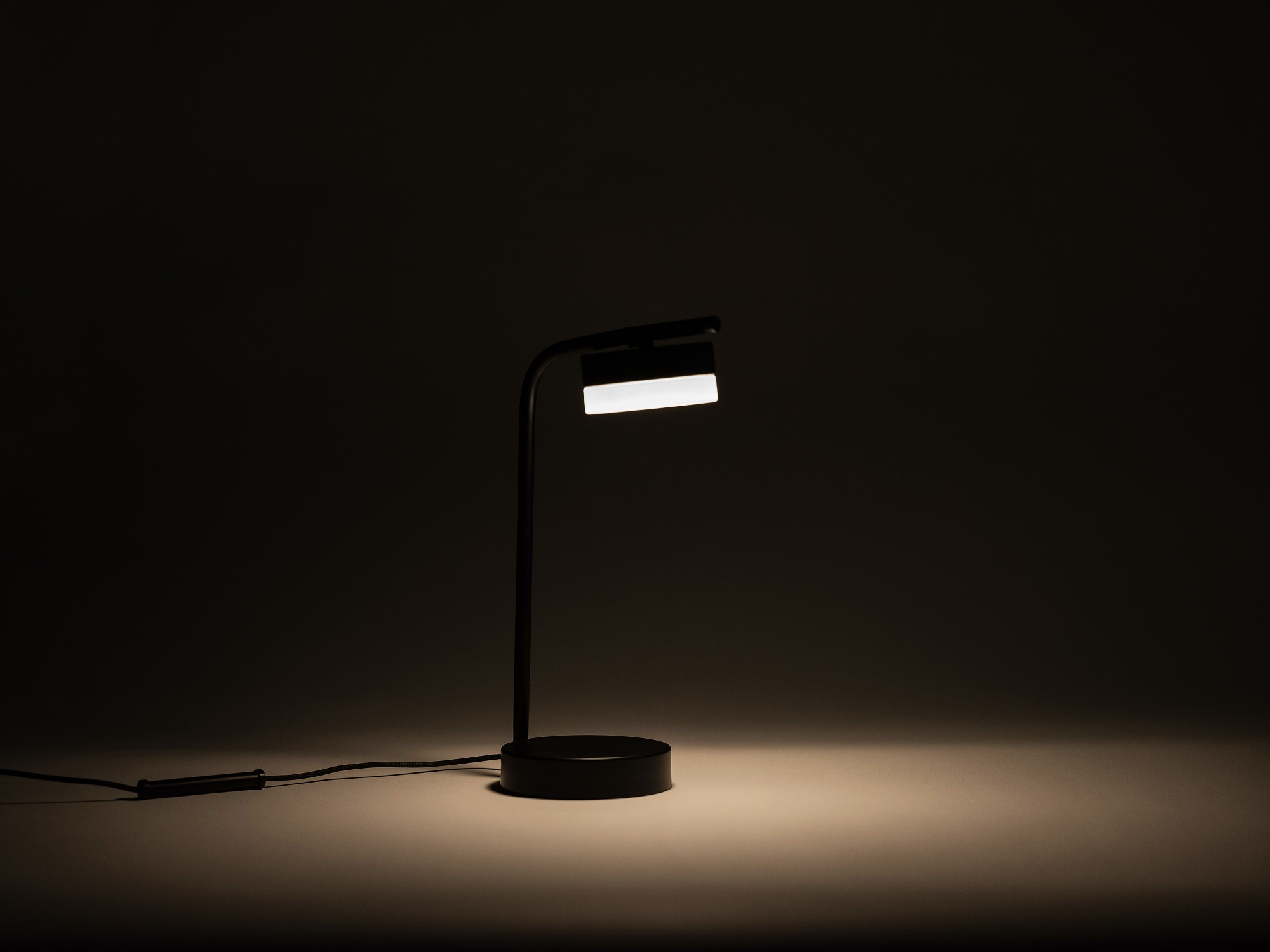 The Row bedside table lamp with light on